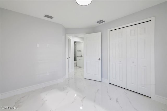 631 Summit Ave S, Lehigh Acres, FL 33974 - unfurnished bedroom with baseboards, marble finish flooring, and a closet