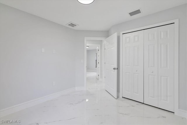 631 Summit Ave S, Lehigh Acres, FL 33974 - unfurnished bedroom featuring light marble finish flooring, baseboards, and a closet