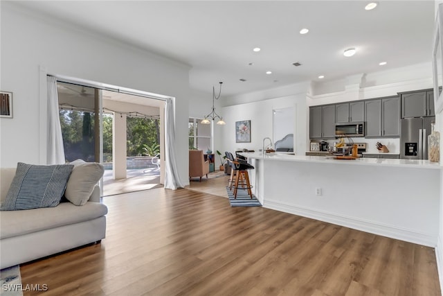 living room featuring crown molding, recessed lighting, wood finished floors, and visible vents