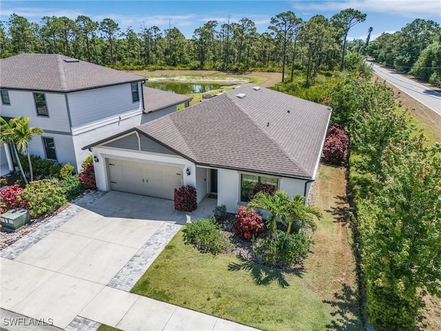 16000 Shoebutton Ct, North Fort Myers, FL 33917 - view of front facade featuring stucco siding, a shingled roof, an attached garage, a water view, and driveway
