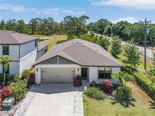 16000 Shoebutton Ct, North Fort Myers, FL 33917 - ranch-style house featuring roof with shingles, an attached garage, concrete driveway, and stucco siding