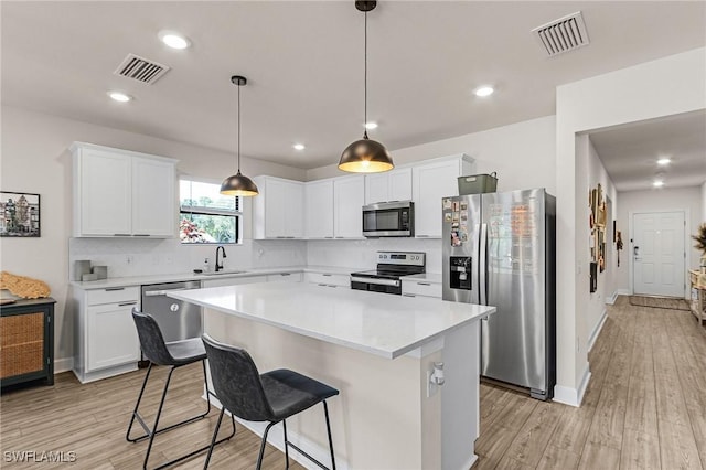 16000 Shoebutton Ct, North Fort Myers, FL 33917 - kitchen featuring appliances with stainless steel finishes, light wood finished floors, visible vents, and a center island