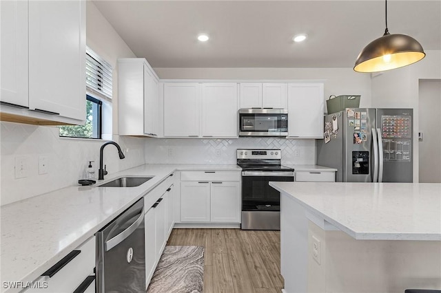 16000 Shoebutton Ct, North Fort Myers, FL 33917 - kitchen featuring light wood-style floors, white cabinets, light stone counters, a sink, and appliances with stainless steel finishes