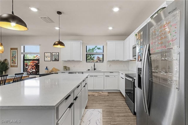 16000 Shoebutton Ct, North Fort Myers, FL 33917 - kitchen with appliances with stainless steel finishes, recessed lighting, light wood-type flooring, a kitchen island, and visible vents
