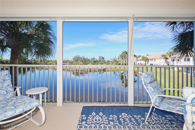 sunroom / solarium featuring a water view