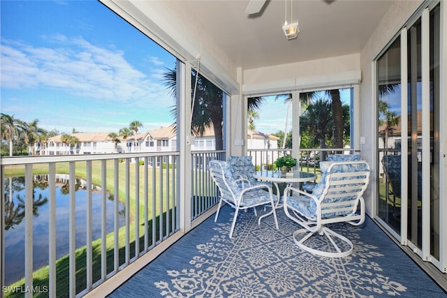 sunroom featuring a water view