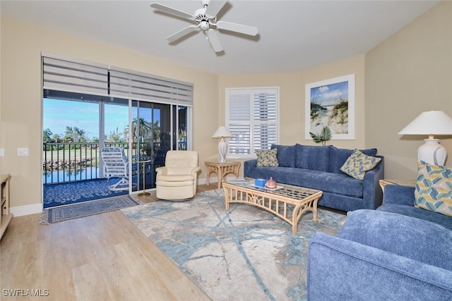 living room with baseboards, ceiling fan, and wood finished floors