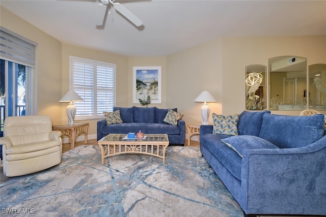 living area featuring baseboards and a ceiling fan