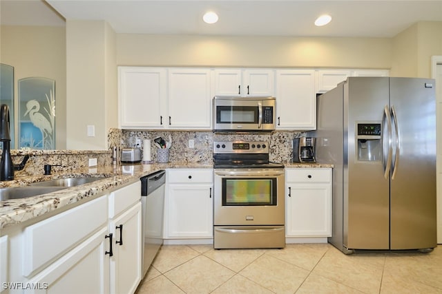 kitchen with white cabinetry, appliances with stainless steel finishes, light tile patterned floors, and tasteful backsplash