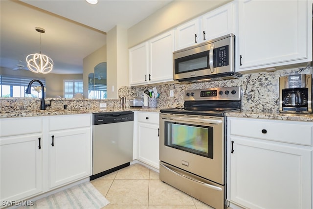 kitchen featuring appliances with stainless steel finishes, tasteful backsplash, a sink, an inviting chandelier, and white cabinetry