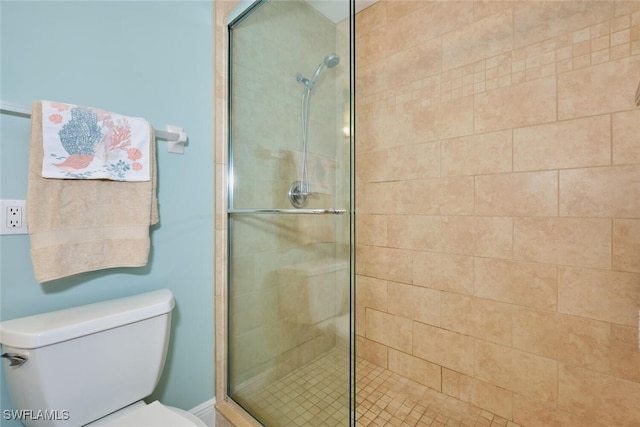 bathroom featuring toilet and a shower stall