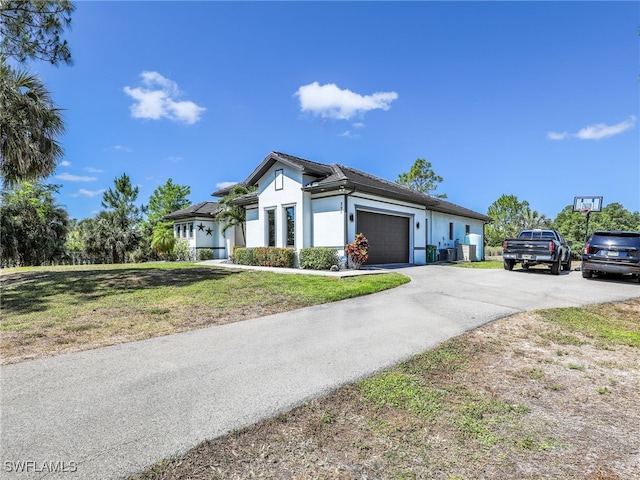 view of home's exterior with a garage, stucco siding, a lawn, and driveway