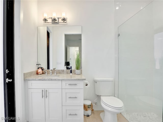 full bathroom with vanity, baseboards, a stall shower, and toilet