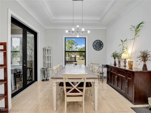 dining room with light tile patterned floors, a raised ceiling, and a chandelier