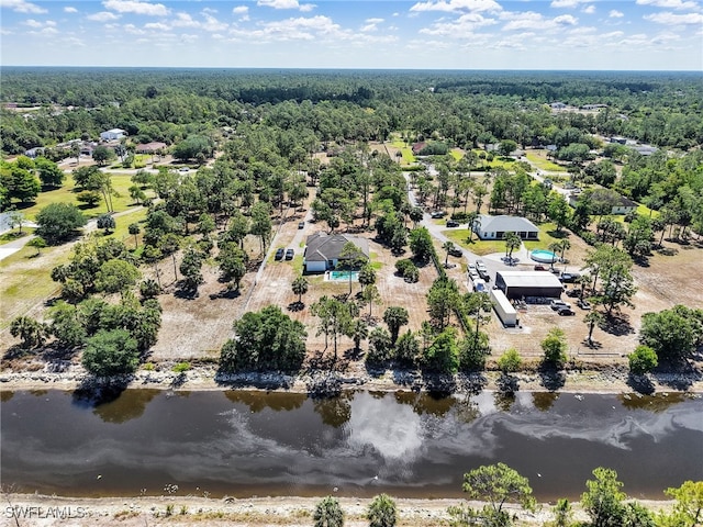 birds eye view of property featuring a water view and a forest view