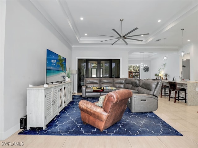 living area featuring a raised ceiling, tile patterned floors, ceiling fan with notable chandelier, and recessed lighting