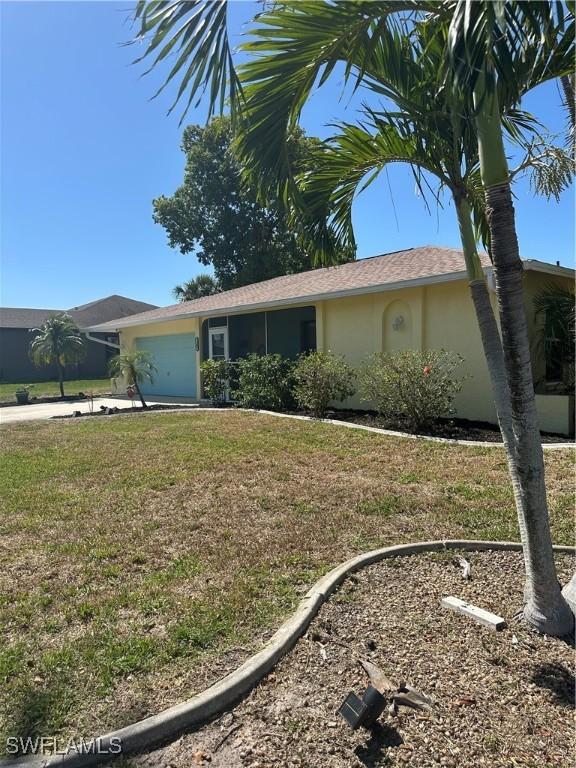 1209 SW 36th Ter, Cape Coral, FL 33914 - single story home with an attached garage, stucco siding, a front lawn, and concrete driveway