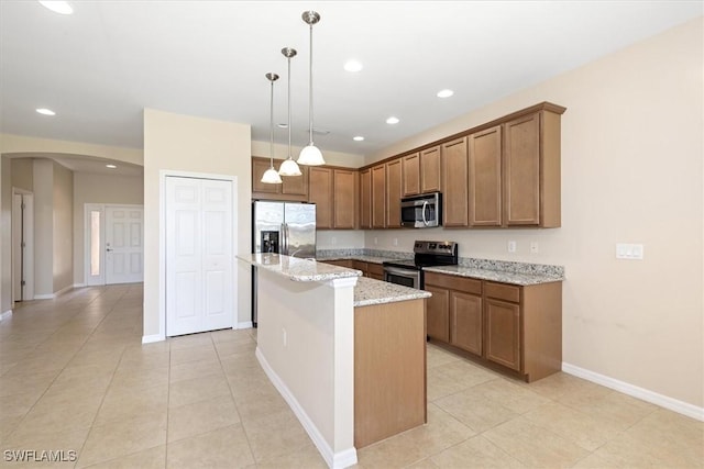kitchen with light stone counters, arched walkways, appliances with stainless steel finishes, and light tile patterned floors