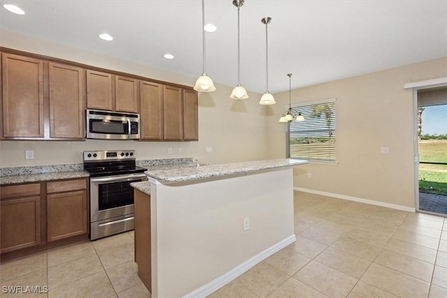 kitchen featuring light tile patterned floors, appliances with stainless steel finishes, brown cabinetry, and a wealth of natural light
