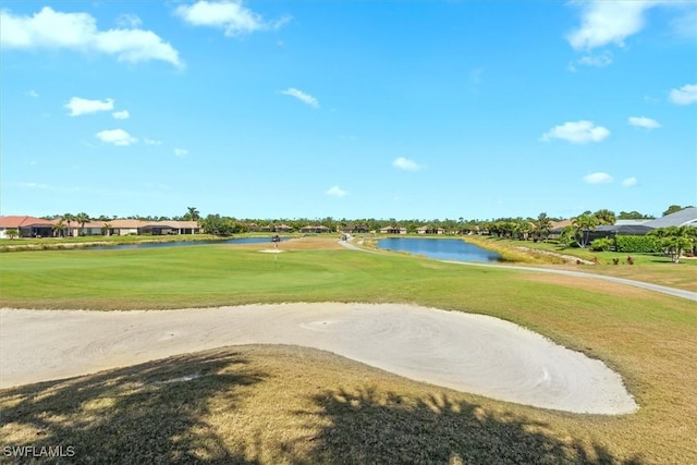 view of property's community with a residential view, view of golf course, a water view, and a yard