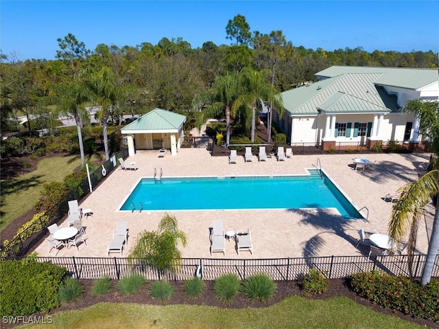 community pool with fence and a patio