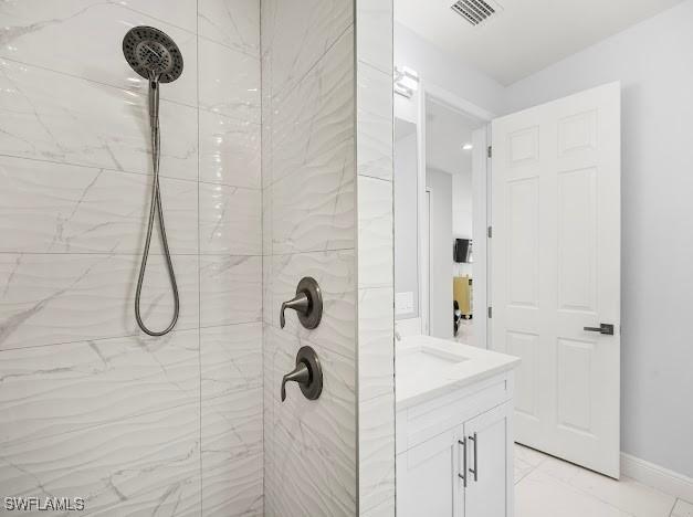 27257 Pinecrest Ln, Bonita Springs, FL 34135 - bathroom with vanity, marble finish floor, baseboards, visible vents, and tiled shower