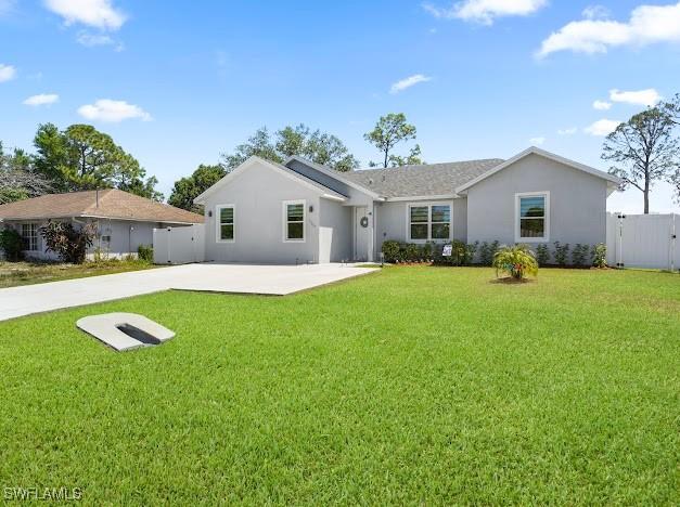 27257 Pinecrest Ln, Bonita Springs, FL 34135 - back of house with a lawn, a patio area, fence, and stucco siding