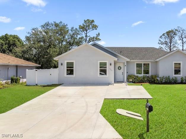 27257 Pinecrest Ln, Bonita Springs, FL 34135 - single story home with stucco siding, fence, a front yard, and concrete driveway