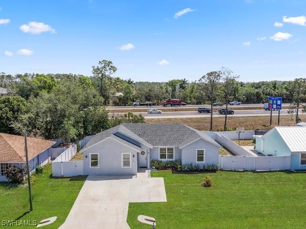27257 Pinecrest Ln, Bonita Springs, FL 34135 - ranch-style house featuring a front lawn, fence, and concrete driveway