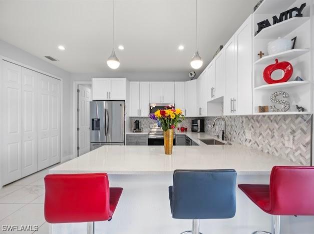 27257 Pinecrest Ln, Bonita Springs, FL 34135 - kitchen with stainless steel refrigerator with ice dispenser, visible vents, open shelves, a sink, and a peninsula
