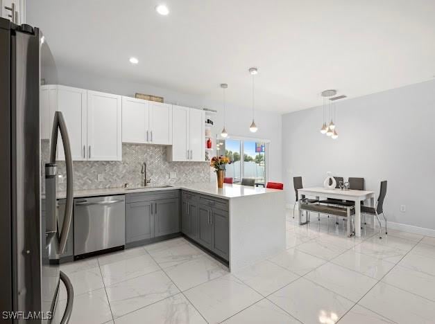 27257 Pinecrest Ln, Bonita Springs, FL 34135 - kitchen featuring marble finish floor, a peninsula, a sink, backsplash, and stainless steel appliances