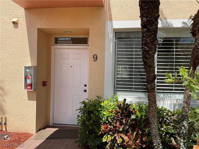 property entrance with stucco siding