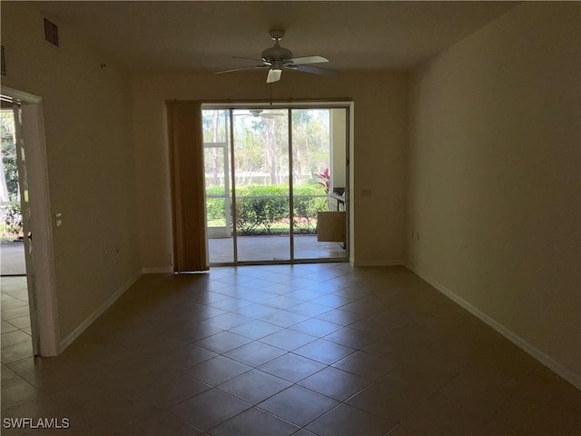 tiled empty room featuring a ceiling fan, baseboards, and visible vents