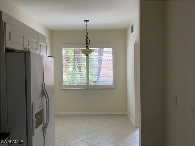 kitchen featuring baseboards, refrigerator with ice dispenser, visible vents, and light tile patterned floors