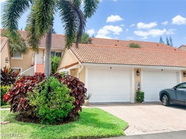 view of front of property featuring an attached garage, stucco siding, and a tile roof