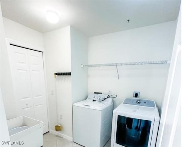 washroom featuring light tile patterned floors, laundry area, and washing machine and clothes dryer