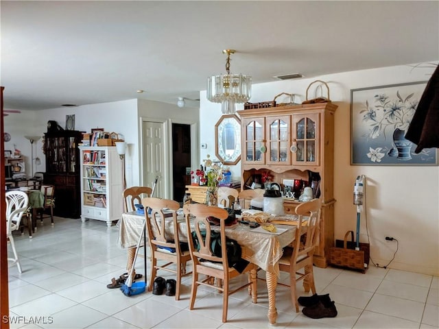 dining space with an inviting chandelier, light tile patterned flooring, and visible vents