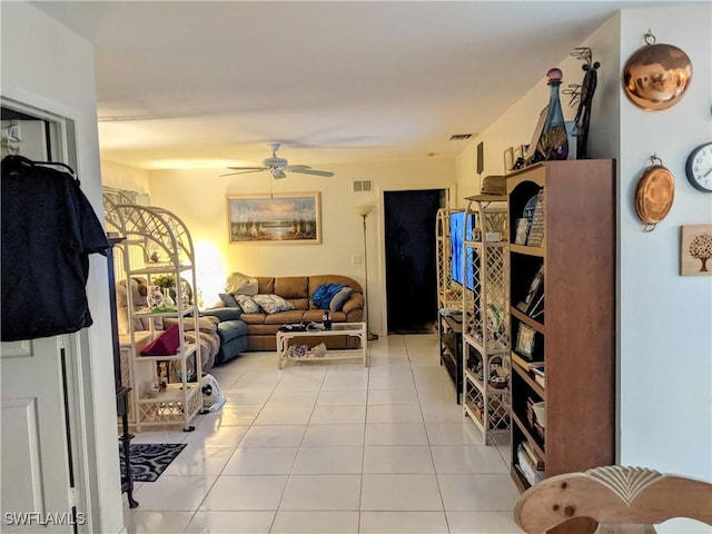 living room with ceiling fan, visible vents, and light tile patterned floors
