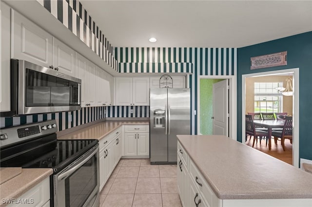 12541 Allendale Cir, Fort Myers, FL 33912 - kitchen with white cabinetry, a kitchen island, light countertops, and appliances with stainless steel finishes