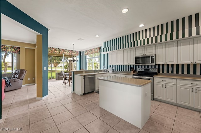 12541 Allendale Cir, Fort Myers, FL 33912 - kitchen with stainless steel appliances, light tile patterned flooring, recessed lighting, white cabinetry, and a center island