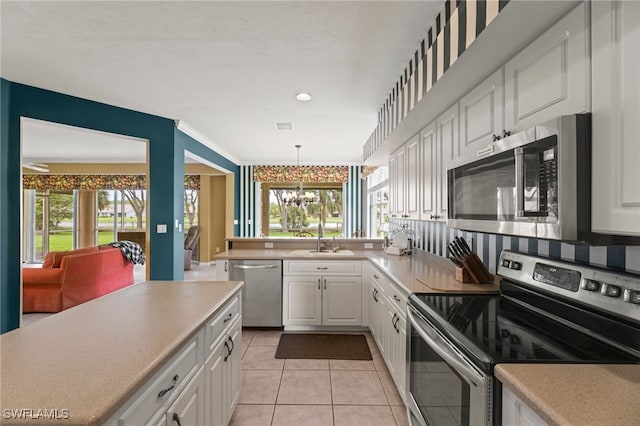 12541 Allendale Cir, Fort Myers, FL 33912 - kitchen featuring a notable chandelier, plenty of natural light, a sink, white cabinets, and appliances with stainless steel finishes