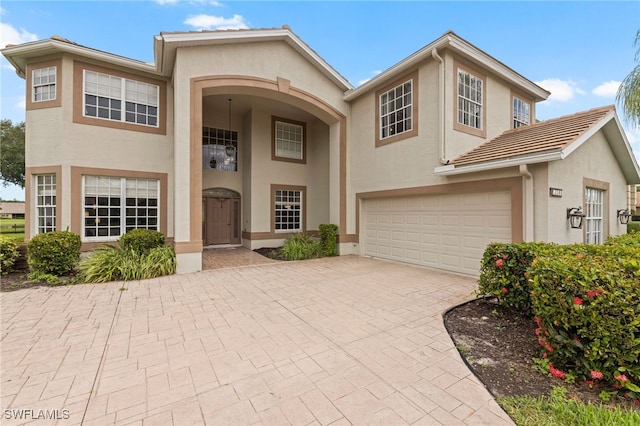 12541 Allendale Cir, Fort Myers, FL 33912 - view of front of home with an attached garage, stucco siding, and decorative driveway