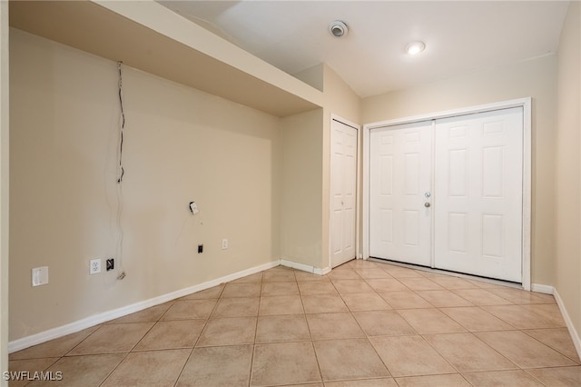 interior space featuring light tile patterned floors and baseboards