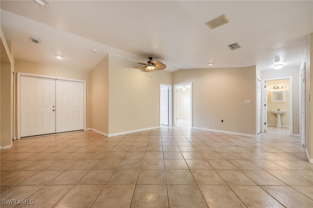 spare room with a ceiling fan, visible vents, light tile patterned floors, and lofted ceiling