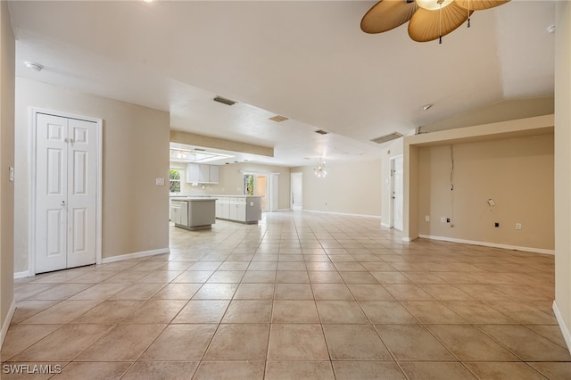 unfurnished living room with light tile patterned floors, baseboards, and a ceiling fan