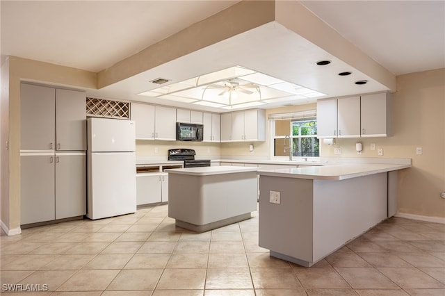 kitchen with black microwave, range with electric cooktop, freestanding refrigerator, a ceiling fan, and visible vents