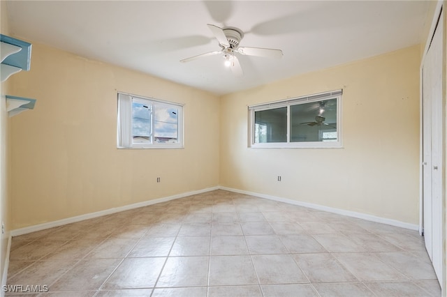 unfurnished room with baseboards, tile patterned flooring, and a ceiling fan