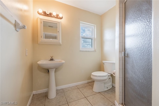 full bathroom with toilet, tile patterned floors, a shower stall, and baseboards