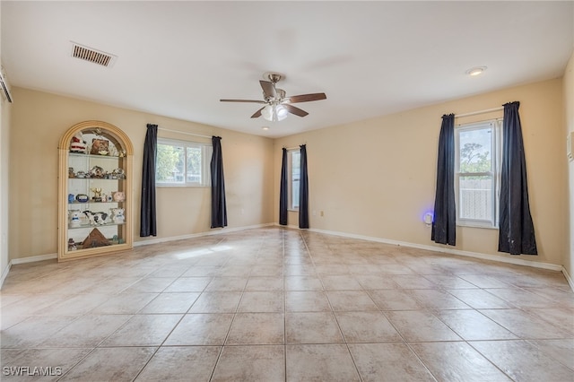 unfurnished room featuring visible vents, a ceiling fan, baseboards, and tile patterned floors