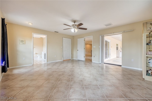 interior space with light tile patterned flooring, ceiling fan, visible vents, and baseboards